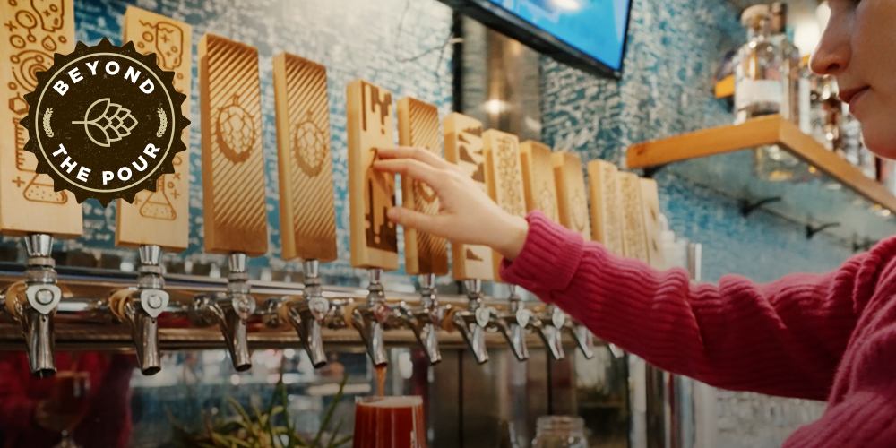 Hand pouring beer at a large tap